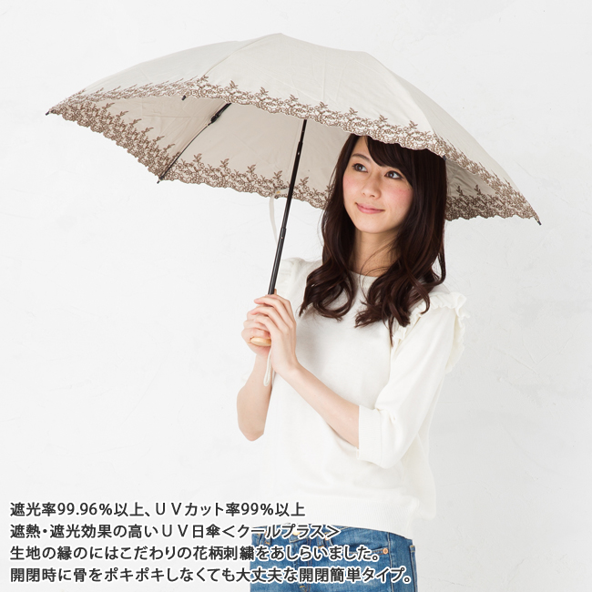 ベージュの傘をさす女性モデル